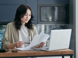 Woman reviewing divorce attorney bills and legal documents at a table